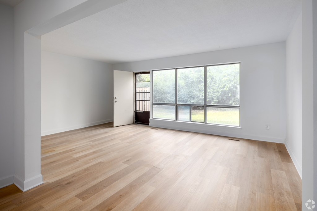 A room with wooden floors and a large window.
