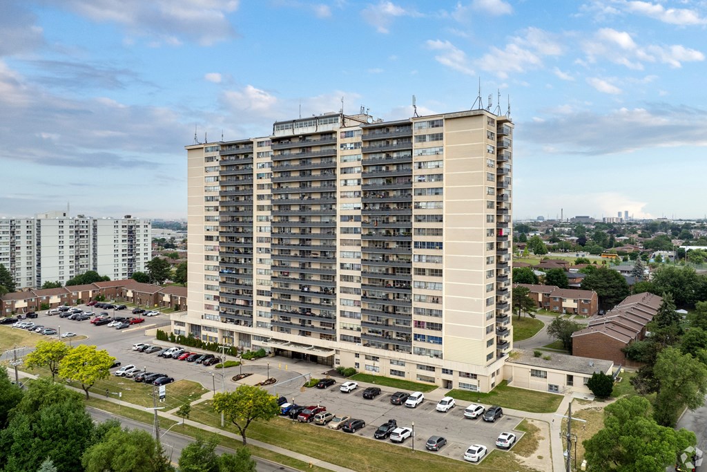 A large apartment building with a parking lot in front.