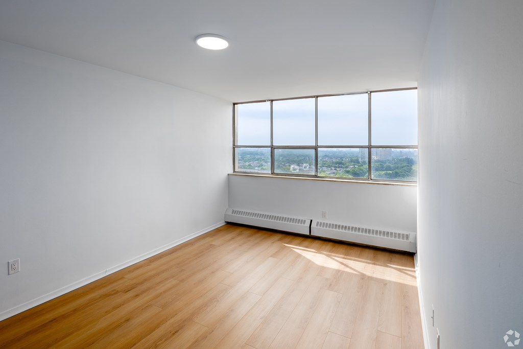 A room with a window overlooking a cityscape.