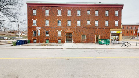 A red brick building with a yellow sign on the right side.