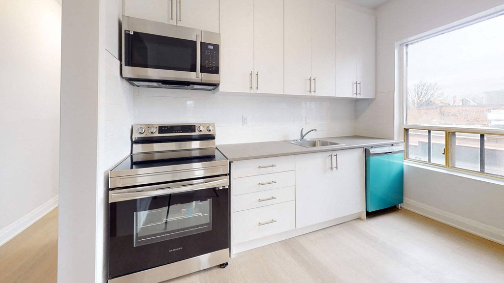 A modern kitchen with white cabinets and a stainless steel oven.