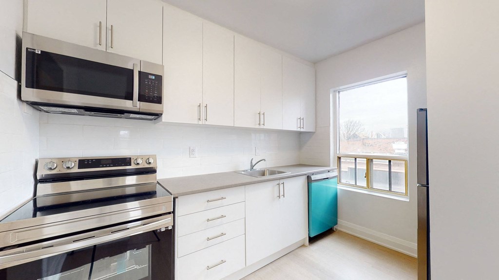 A kitchen with white cabinets and a stainless steel oven.