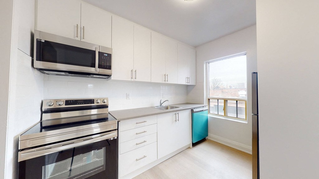 A kitchen with white cabinets and a black stove top oven.