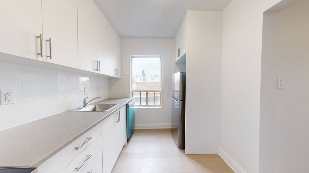 A kitchen with white cabinets and a blue island.