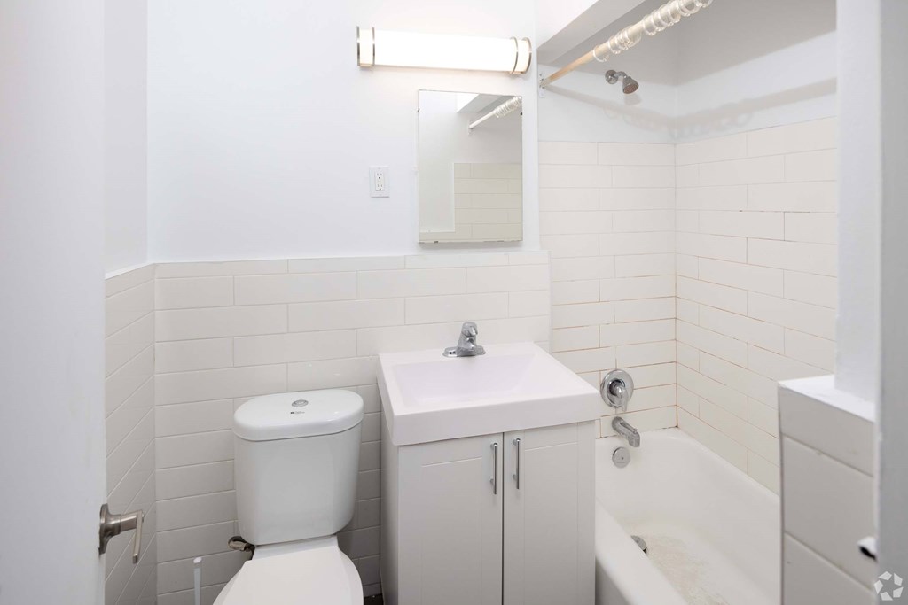 A white toilet sits next to a sink in a small bathroom.