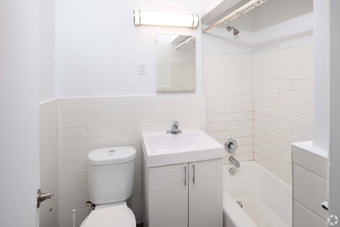 A white toilet sits next to a sink in a small bathroom.