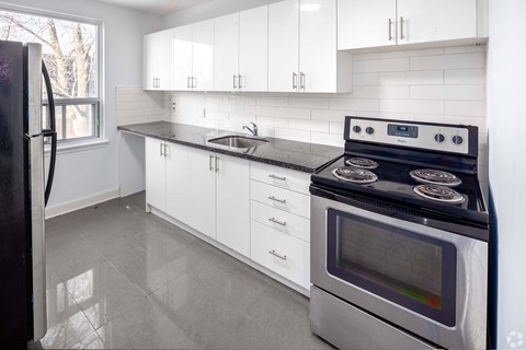 A modern kitchen with a stove and a refrigerator.