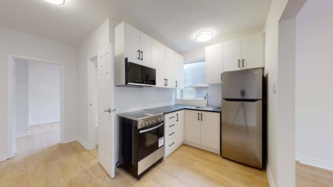 A kitchen with a stove, oven, refrigerator, and microwave.