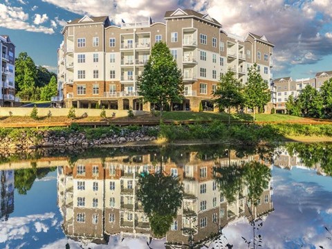 A large building with a pond in front of it.