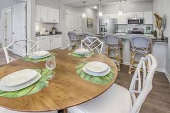 A dining room with a table set for two with green placemats.