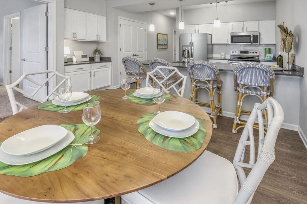 A dining room with a table set for two with green placemats.