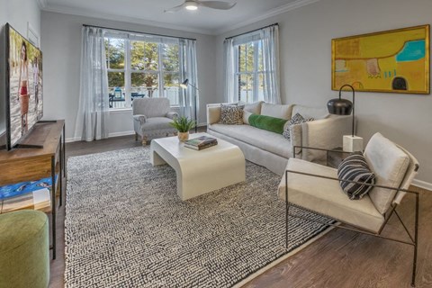 A living room with a white couch, a coffee table, and a painting on the wall.