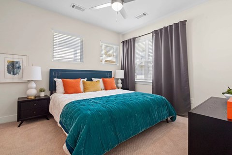 A bedroom with a bed, nightstand, and window.