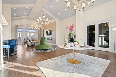 A living room with a white table and a chandelier.