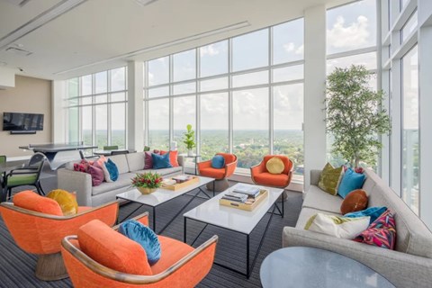 A living room with a grey couch, orange chairs and a coffee table.