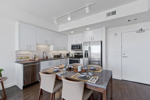 A modern kitchen with a dining table set for two.