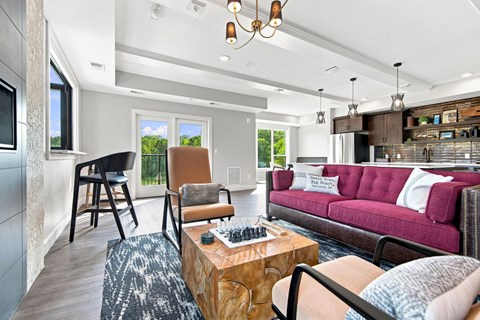 A living room with a red couch and a wooden coffee table.