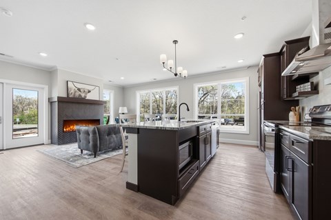 A modern kitchen with dark wood floors and a large island.