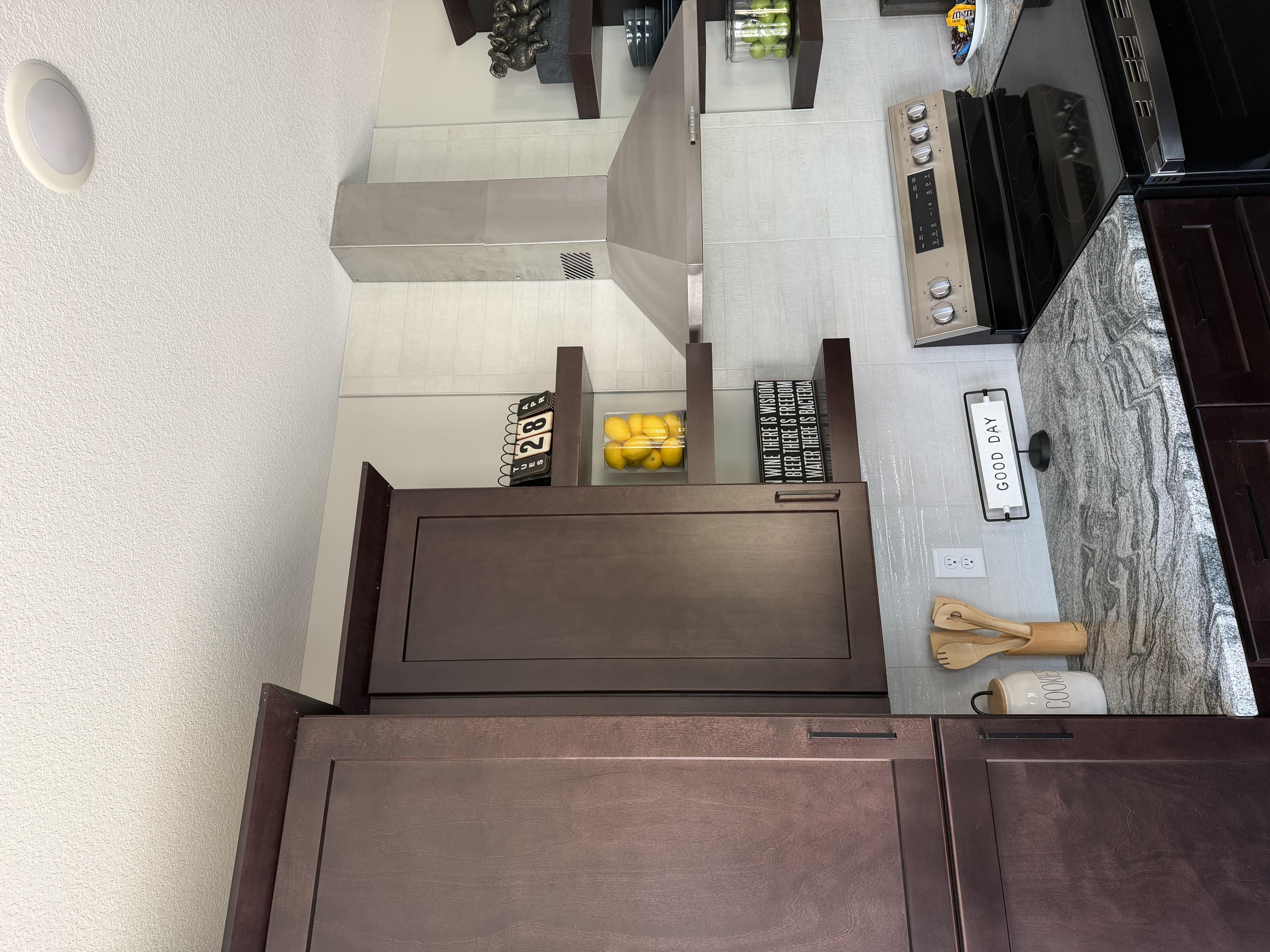 A kitchen with brown cabinets and a white wall.