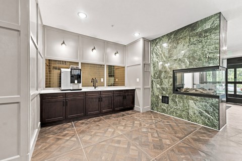 A kitchen with a marble backsplash and dark wood cabinets.
