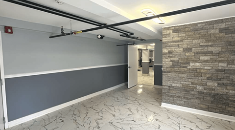 A room with a grey wall and a stone wall.