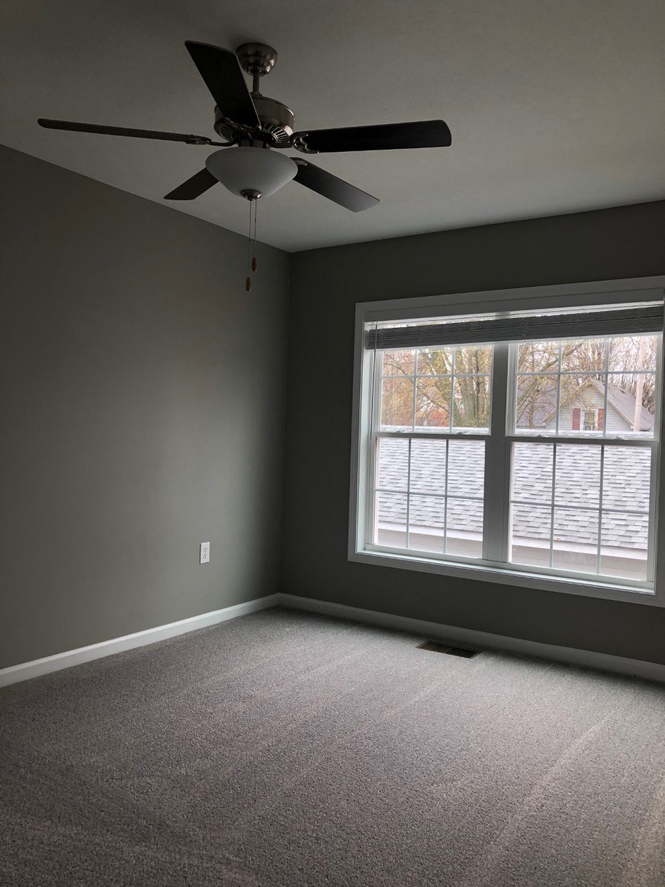 a living room with a ceiling fan and a large window