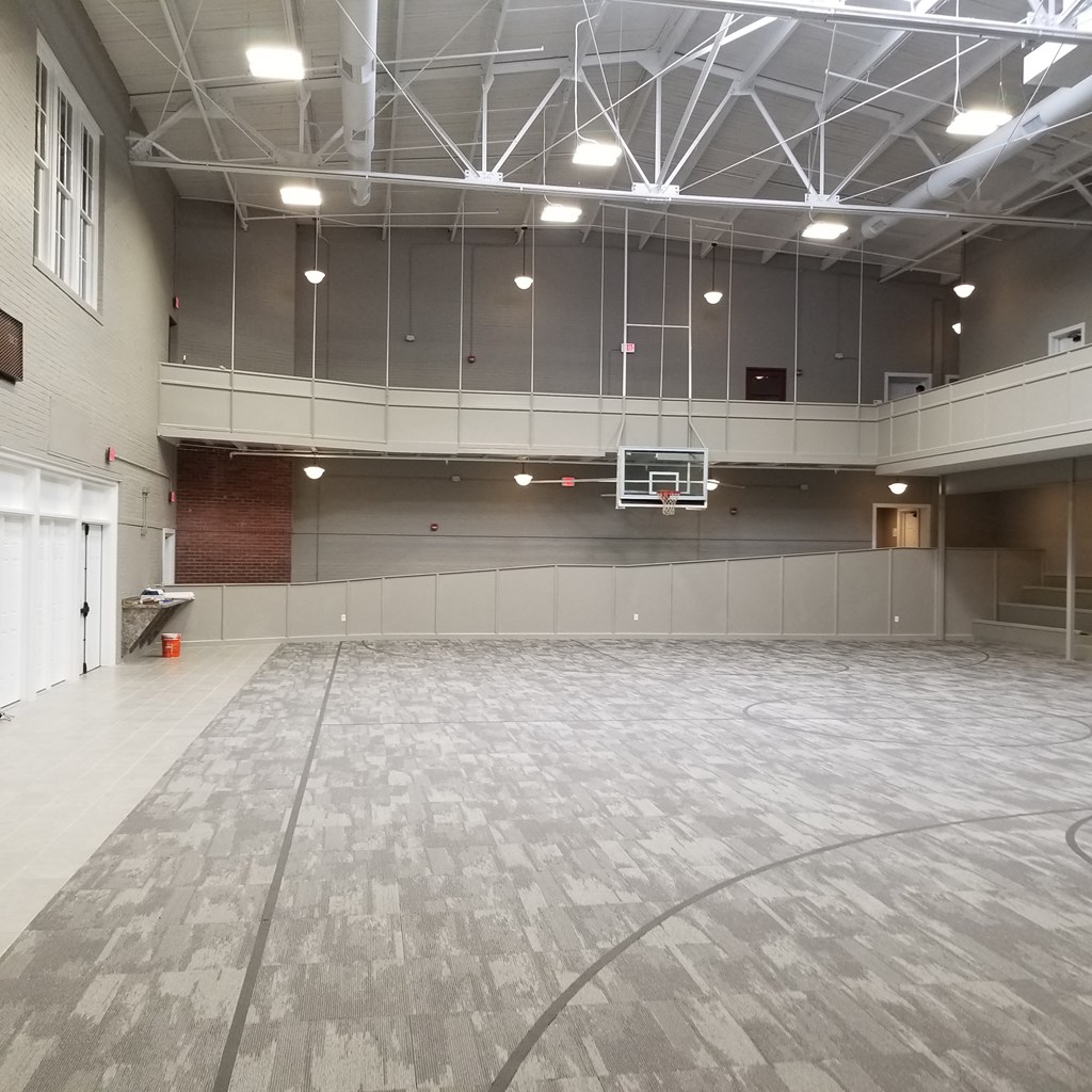 an empty gym with a basketball hoop in the middle of the floor