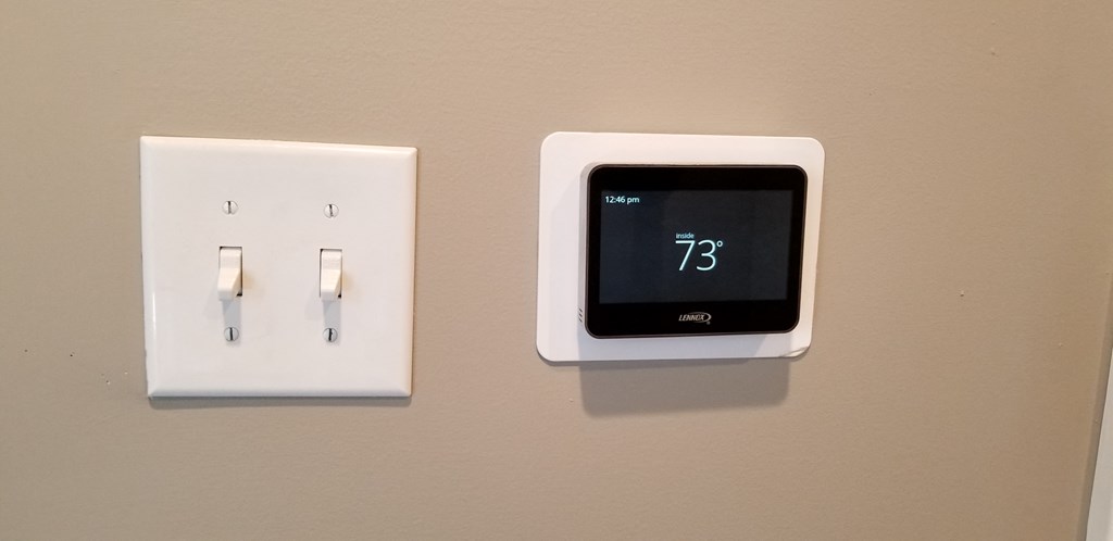 a thermostat and a clock on a wall