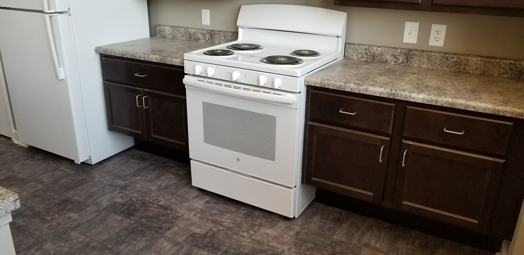 a kitchen with a stove and counter tops and a refrigerator