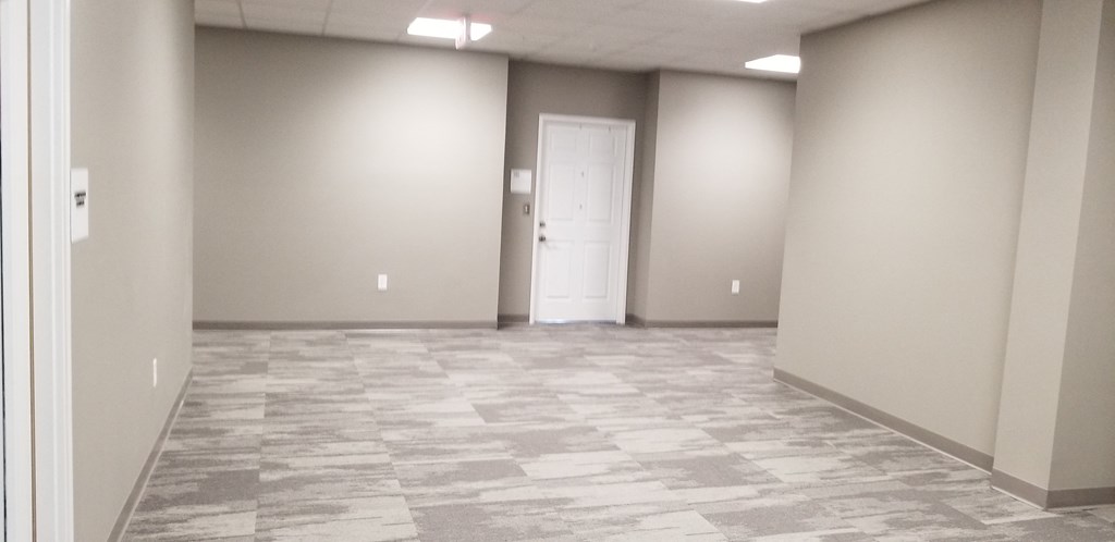 an empty room with white walls and a door