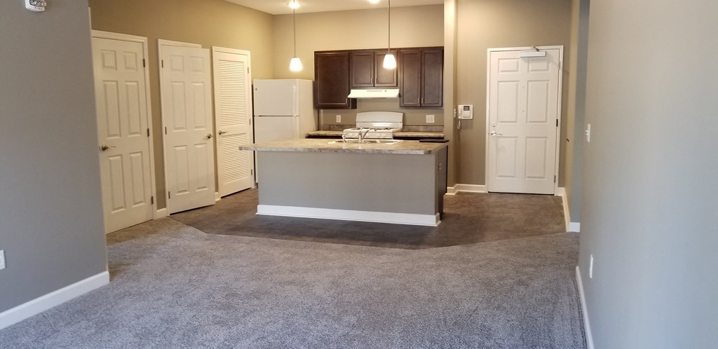 an empty kitchen with an island in the middle of it