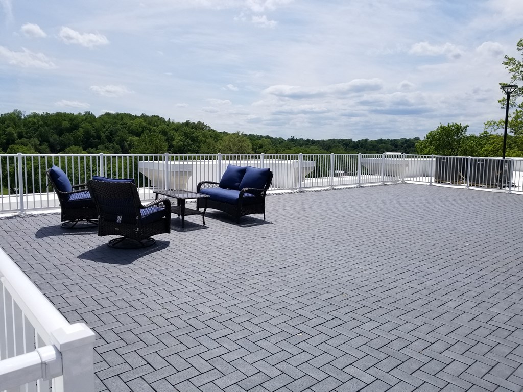 a patio with chairs and a table on top of a roof