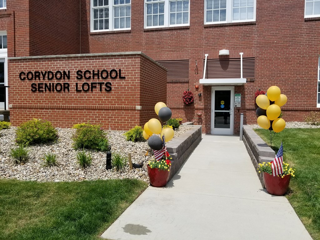 the front entrance of cooper school senior lofts with balloons in front of the building