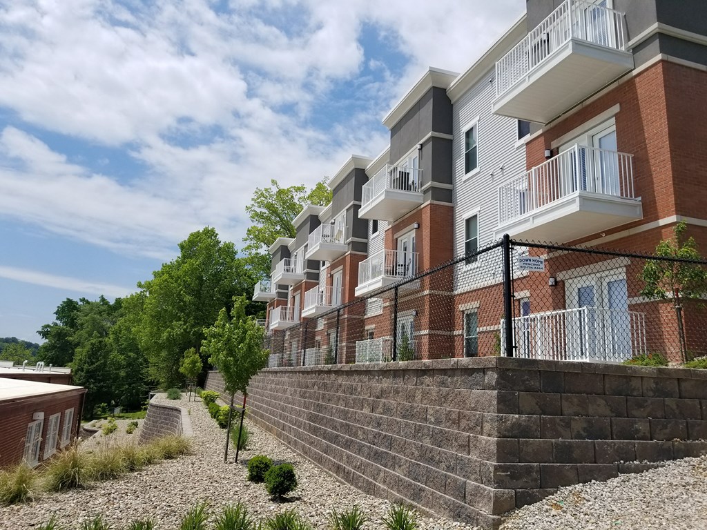 an apartment building with a stone wall in front of it