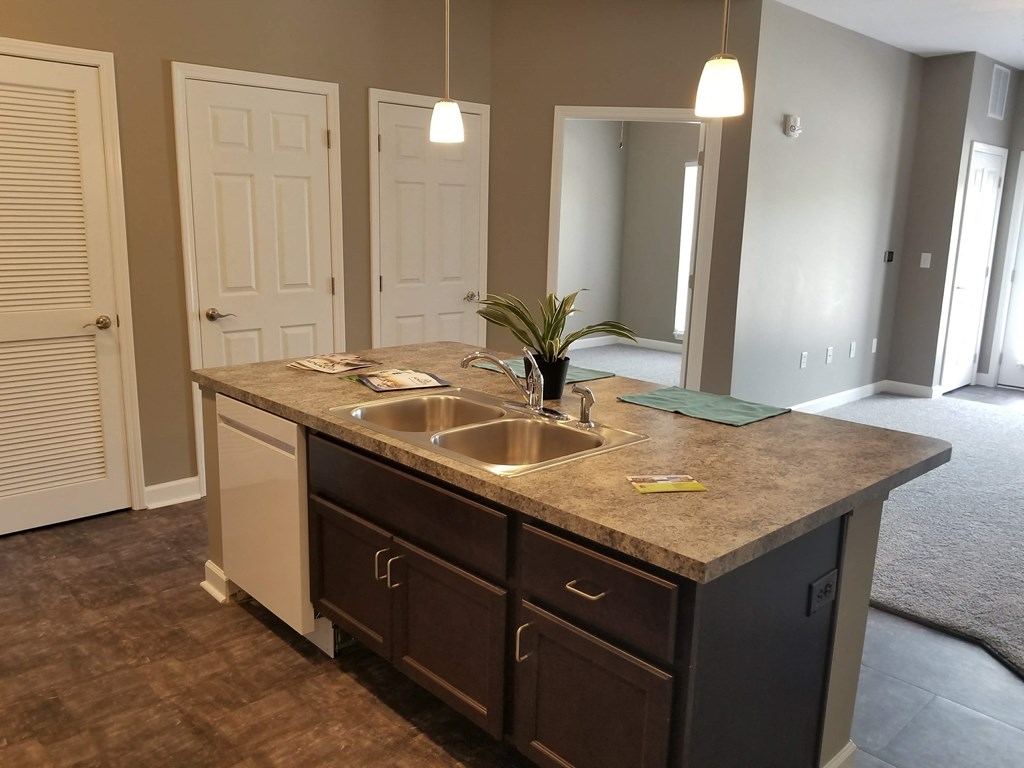 an empty kitchen with a granite counter top and a sink