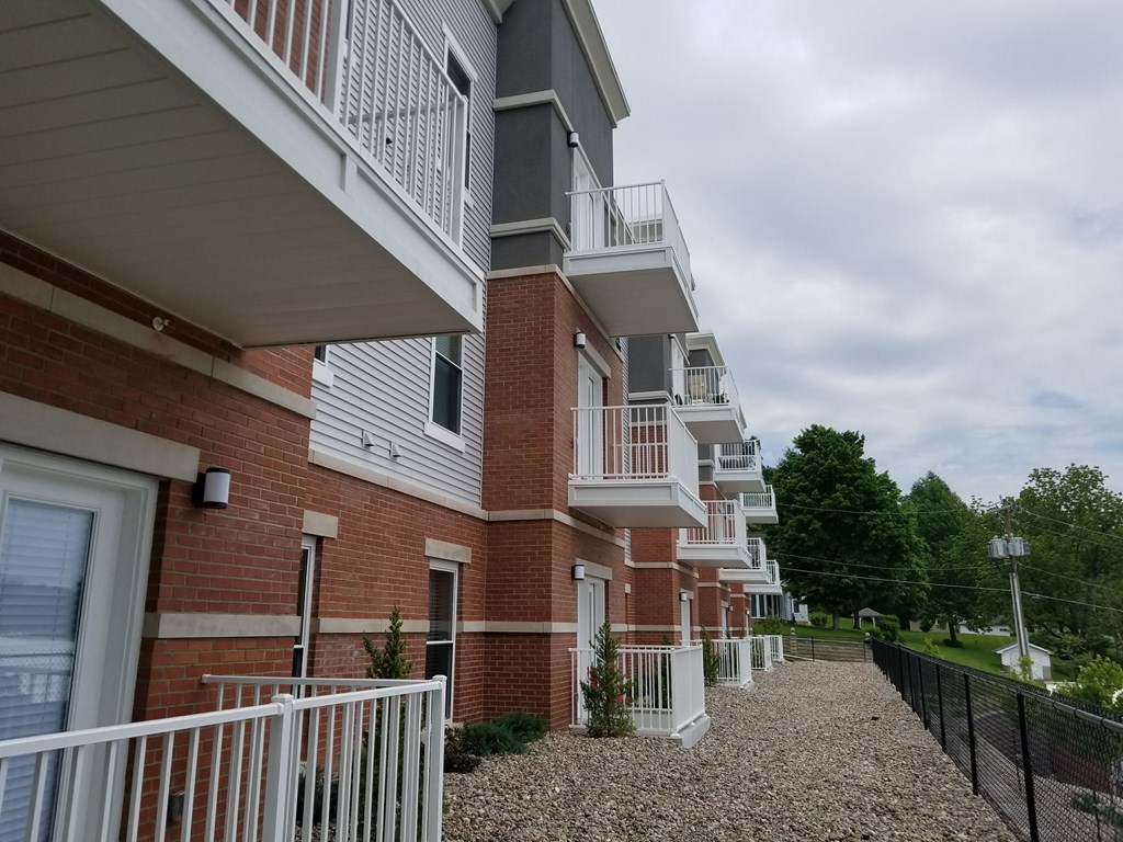 an apartment building with balconies and a gravel pathway