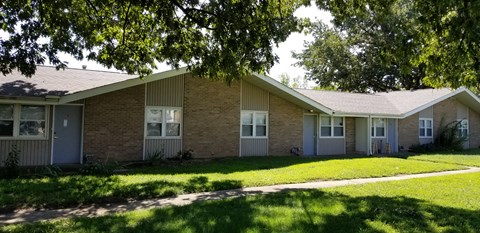 a brick house with a lawn in front of it