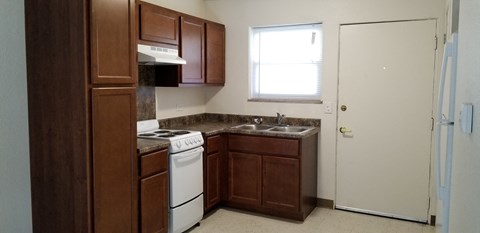 an empty kitchen with a stove refrigerator and sink