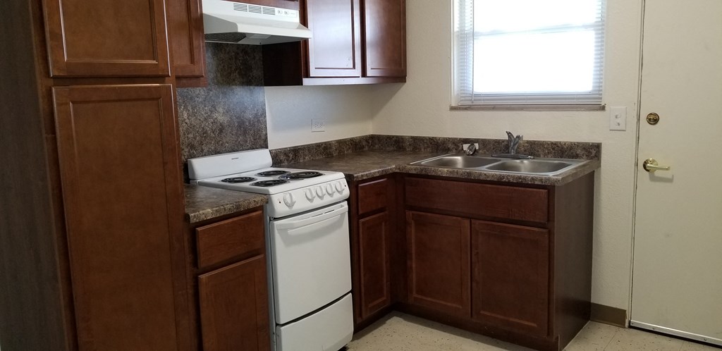 an empty kitchen with a stove and a sink