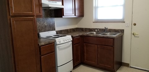 an empty kitchen with a stove and a sink