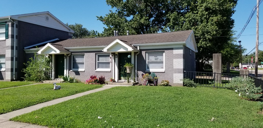 a house with a lawn and a sidewalk in front of it
