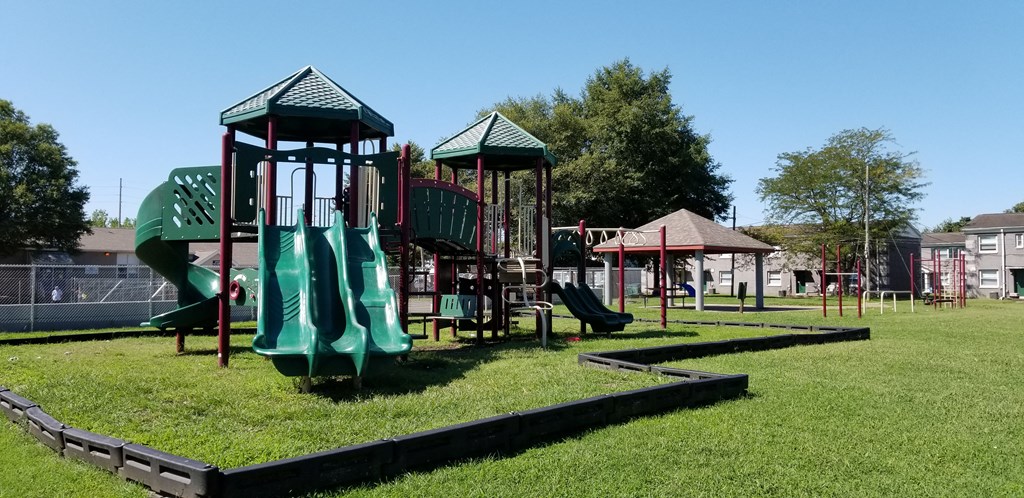 a playground with slides and other play equipment in a park