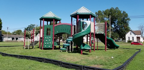 a playground with a green and red play set