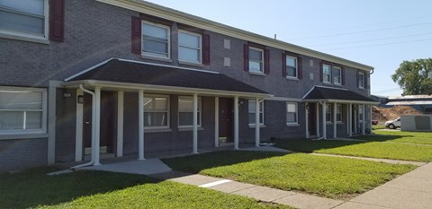 a brick house with a sidewalk in front of it
