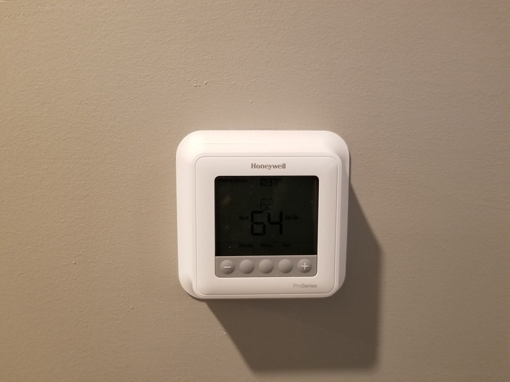 the thermostat is on the wall and the light is on