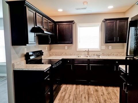 a kitchen with dark wood cabinets and granite counter tops