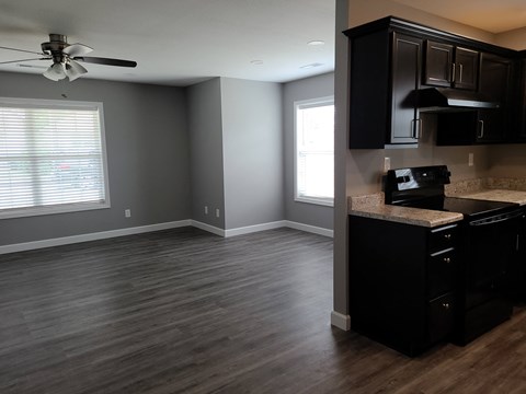 an empty kitchen and living room with wood flooring