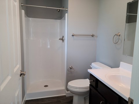 an empty bathroom with a shower toilet and sink