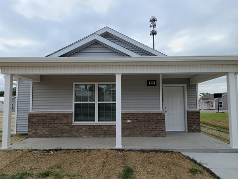the front of a house with a porch and a white door