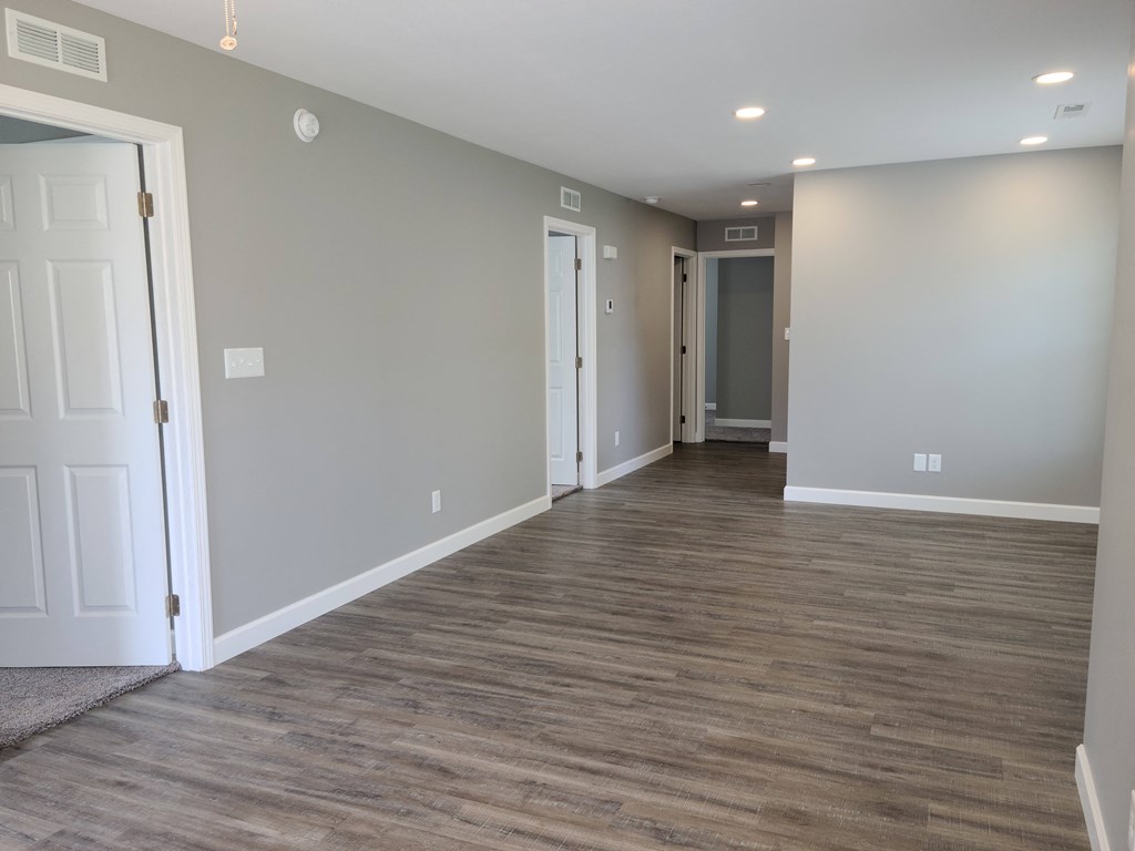 a living room with a wood floor and grey walls and white doors